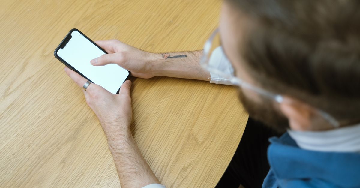 person checking phone while another person wears smart glasses in a cafe