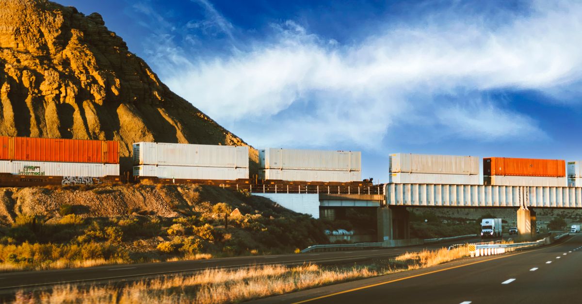 futuristic autonomous freight train beside a stack of gold bars