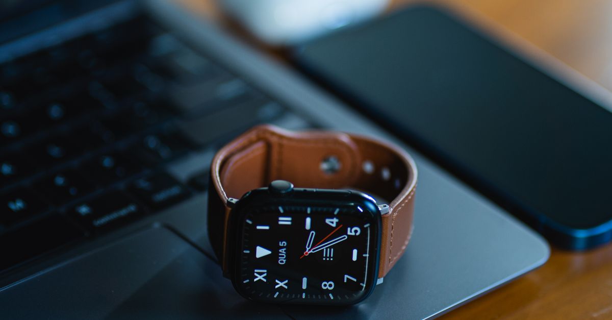 sleek smartwatch beside Android phone and laptop with glowing LED strip