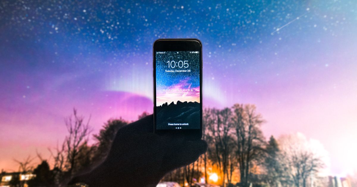 a hand holding a smartphone displaying a galaxy background