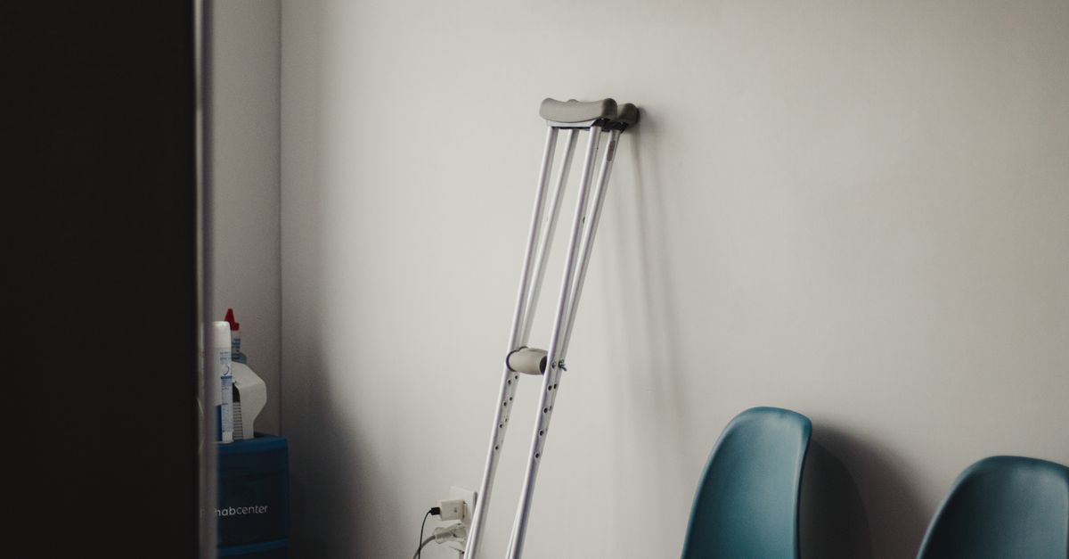 crowded clinic waiting room with empty vaccine fridge
