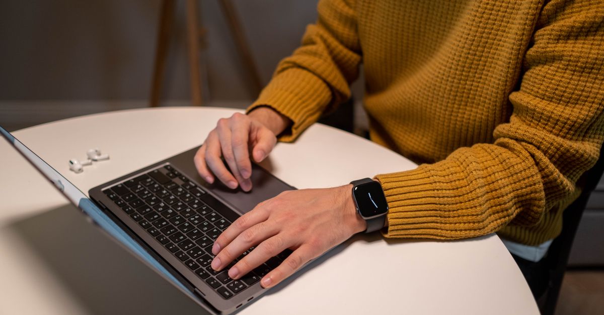 Apple engineer working on a sleek smart speaker and earbuds in a modern office