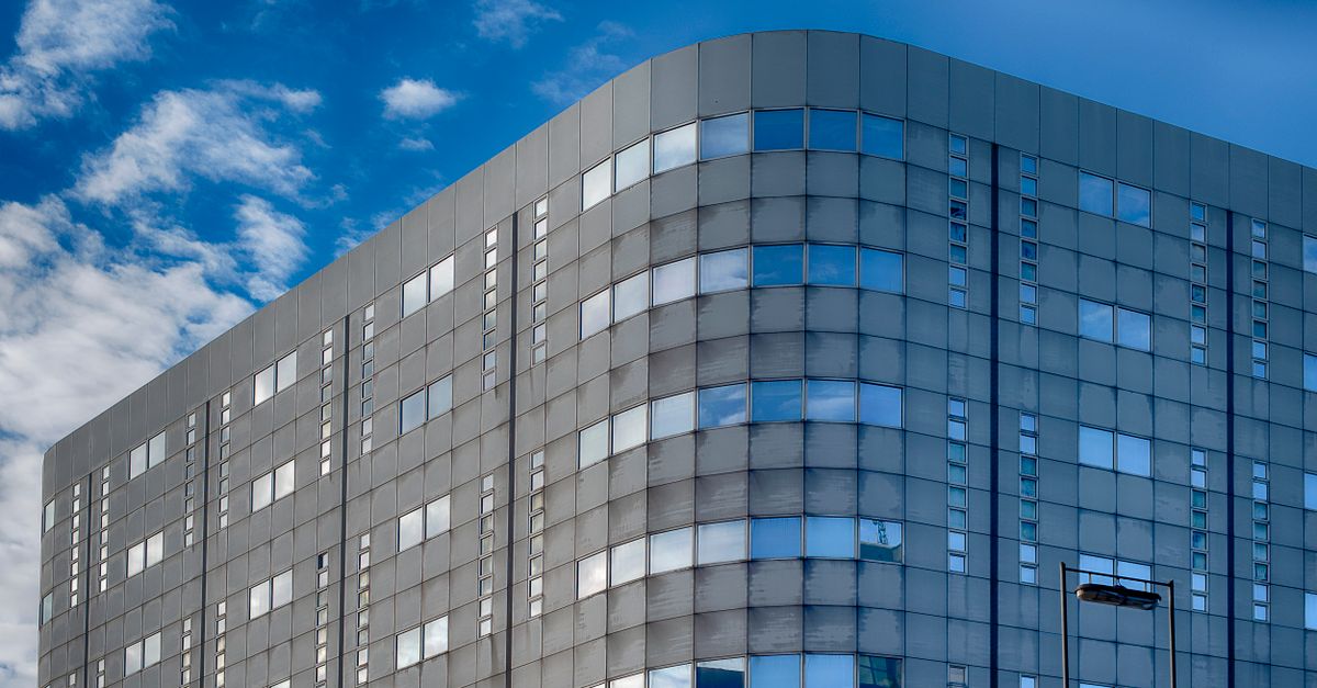 Meta office building under cloudy sky with digital ad icons fading