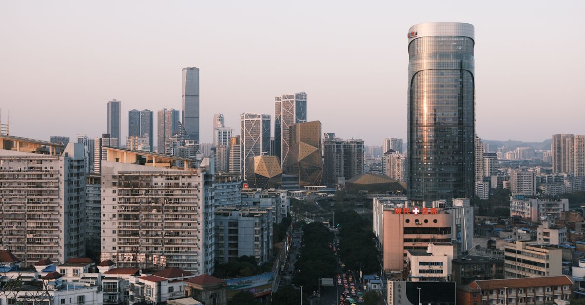 Apple devices on a Chinese city skyline at dusk