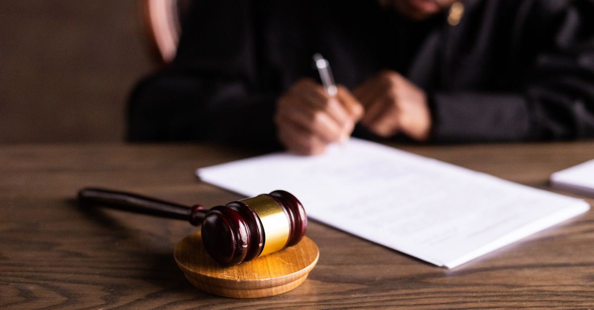 two smart rings on a courtroom table, legal documents scattered, muted lighting
