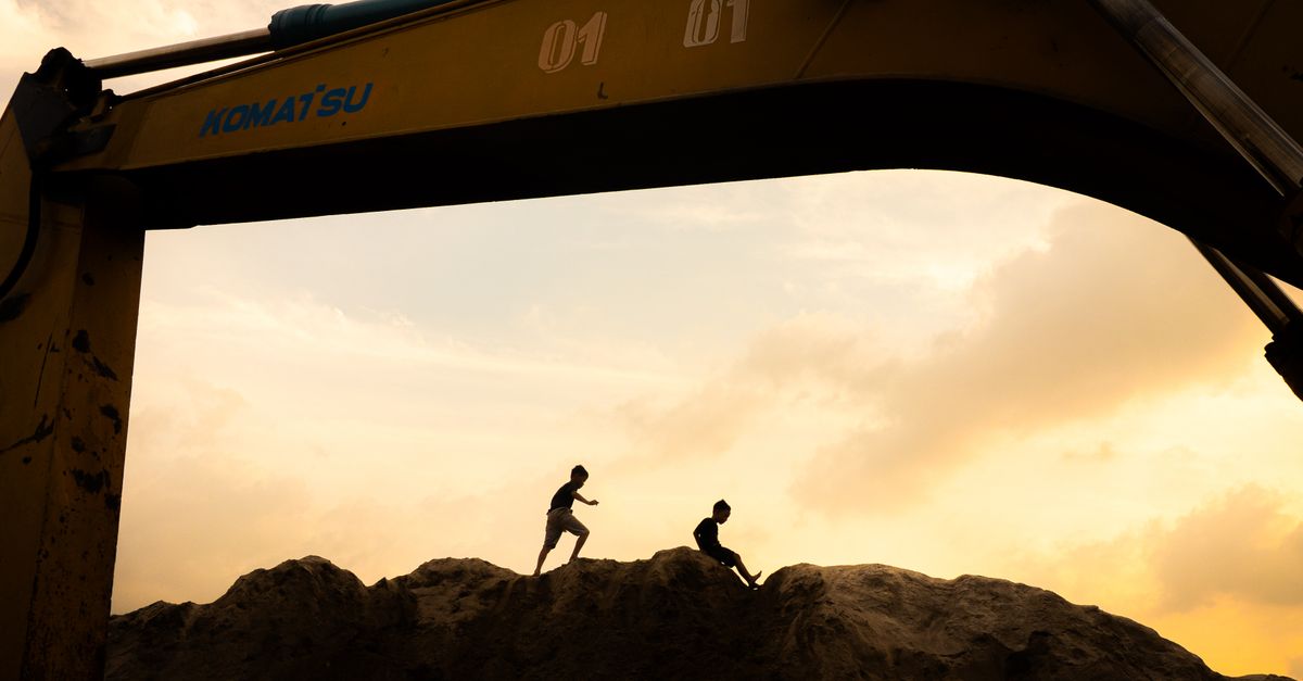 autonomous excavator operating on a construction site at dusk