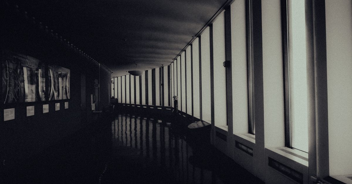 modern office corridor with empty desks and dim lighting