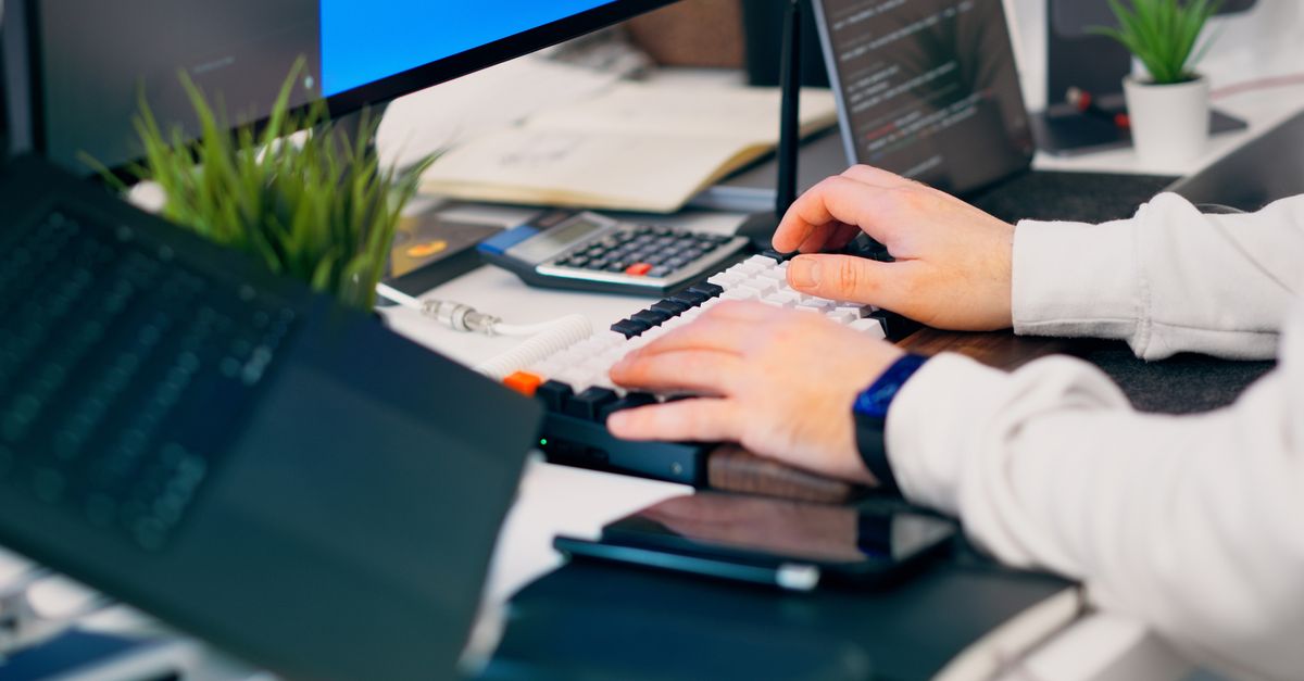 office desk with AI code screens and security alerts